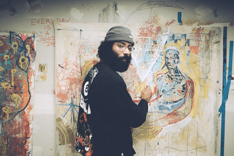 Man in beanie drawing on wall